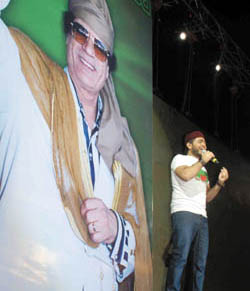 Tamer Hosni devant une image gante du leader libyen.